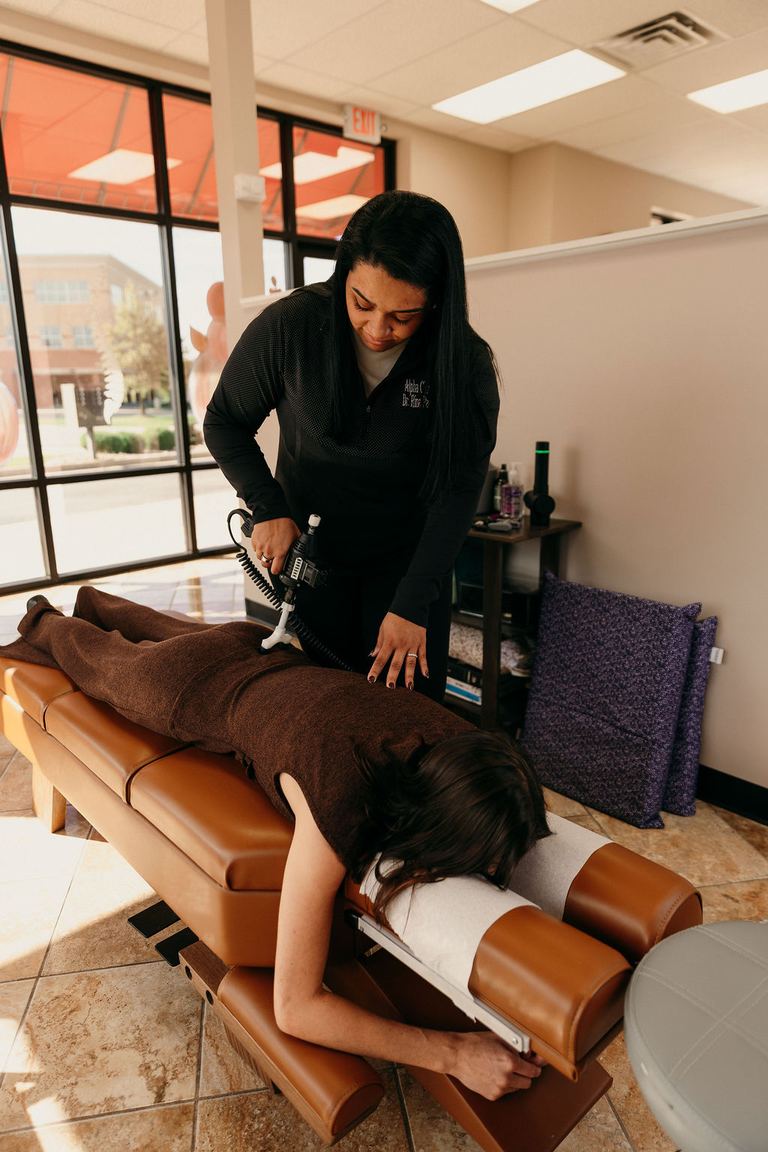 Dr. Rina Patel-Jerls working with a patient in the Alpha Chiropractic treatment room